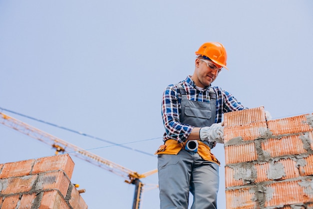 Young craftsman building a house