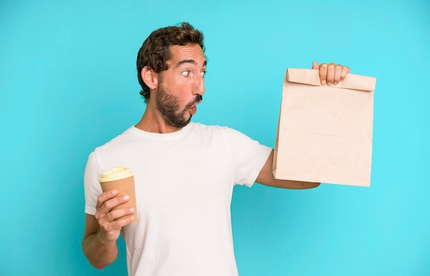 Photo young crazy bearded and expressive man with a take away paper bag