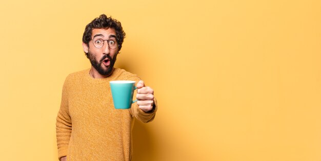 Young crazy bearded man with a coffee cup