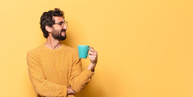 Young crazy bearded man with a coffee cup