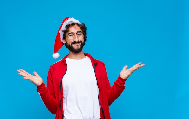 Young crazy bearded man with santa hat. Christmas concept