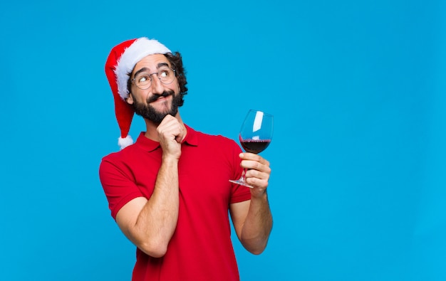 Young crazy bearded man with santa hat. Christmas concept