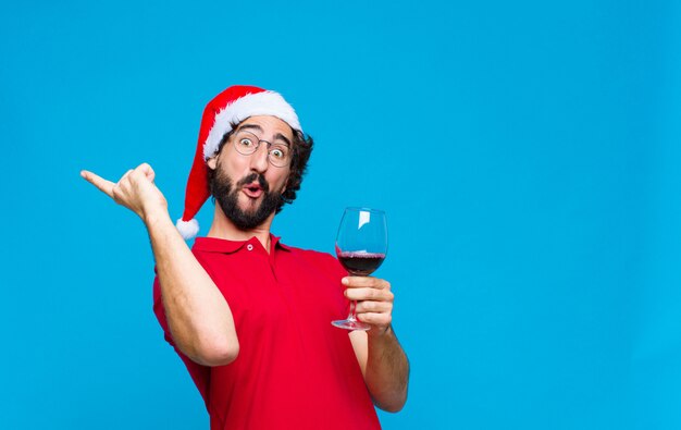 Young crazy bearded man with santa hat. Christmas concept