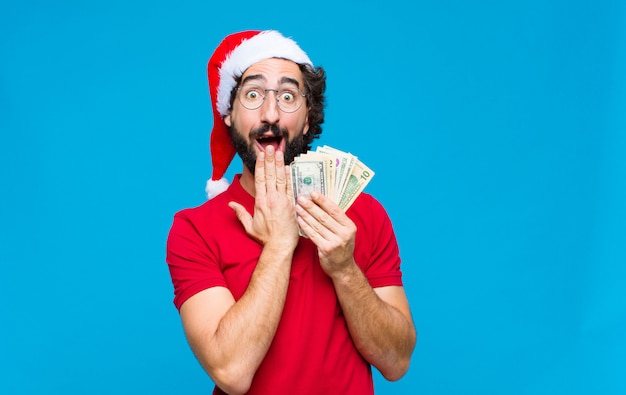 Young crazy bearded man with santa hat. Christmas concept