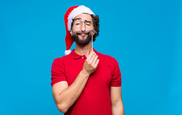 Young crazy bearded man with santa hat. Christmas concept