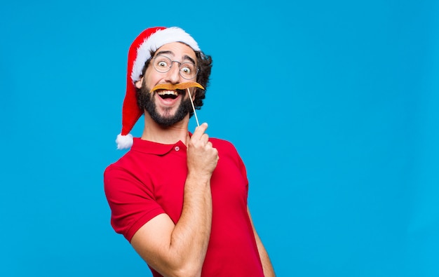 Young crazy bearded man with santa hat. Christmas concept