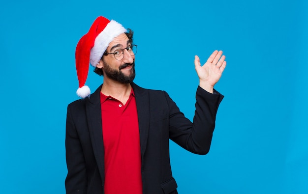 Young crazy bearded man with santa hat. Christmas concept