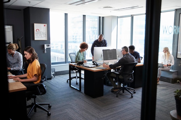 Young creative team working together at computers in a casual office seen from doorway