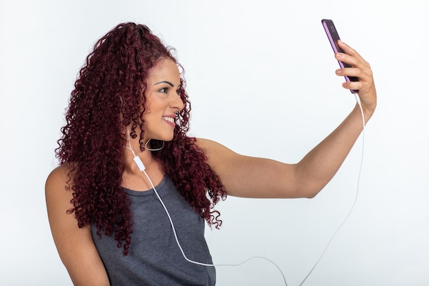 Young curly woman in casual clothes taking a selfie