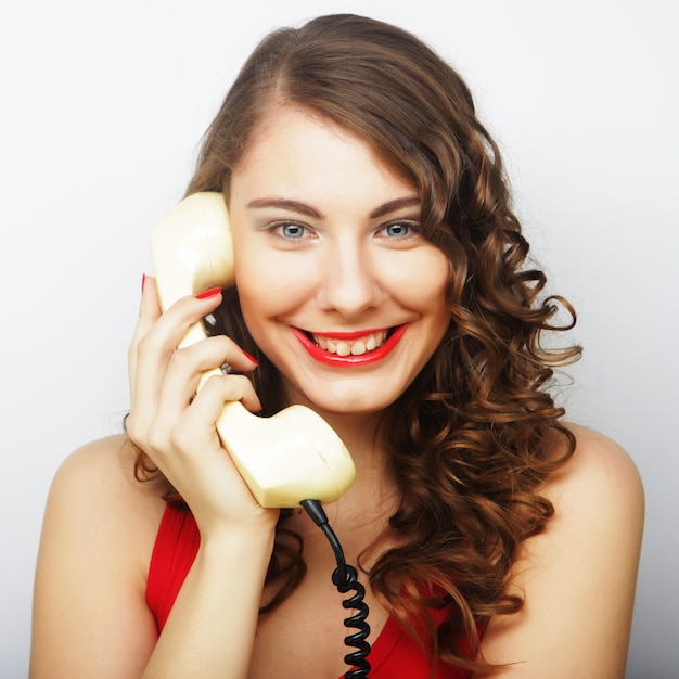 Young curly woman with vintage phone.