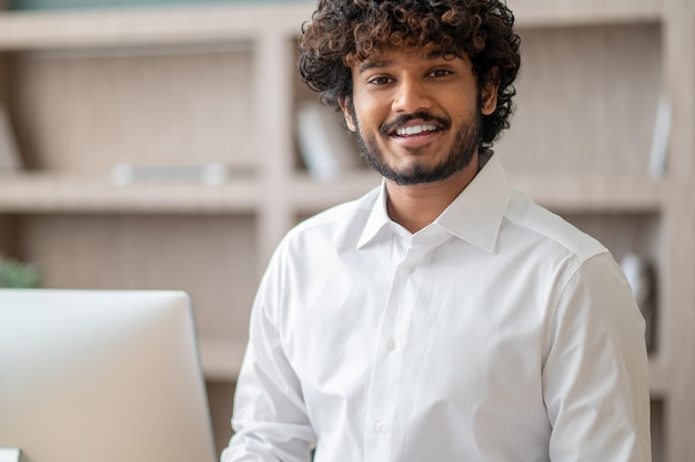 Young curlyhaired manager feeling busy at work