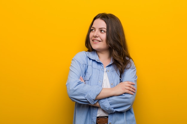 Young curvy plus size woman smiling confident with crossed arms.