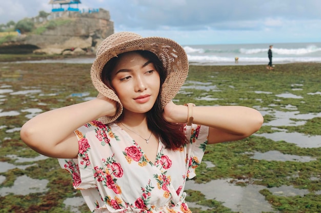 A young cute Asian girl wearing a sun hat is relaxing on the blue sky beach at Gunungkidul Indonesia