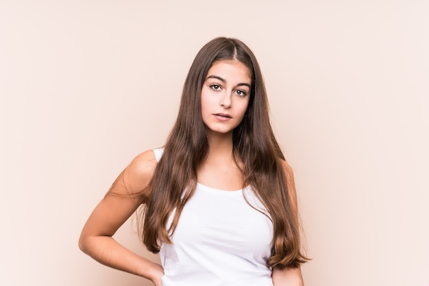 Young cute caucasian woman against a beige wall