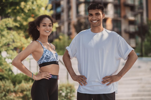 Young cute couple in sportswear looking joyful