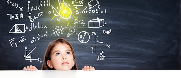 Young cute girl at chalkboard with light bulb over head