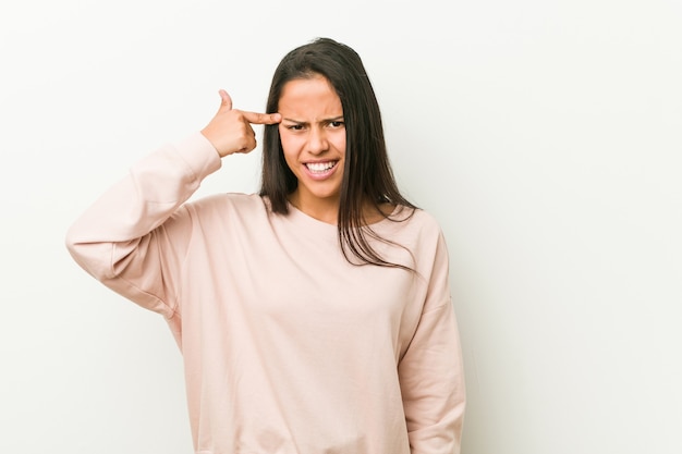 Young cute hispanic teenager woman showing a disappointment gesture with forefinger.