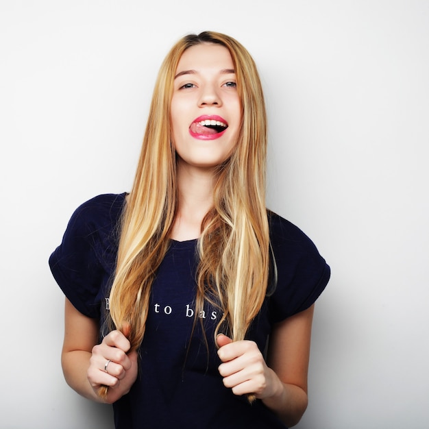 Young cute smiling blond girl over white background