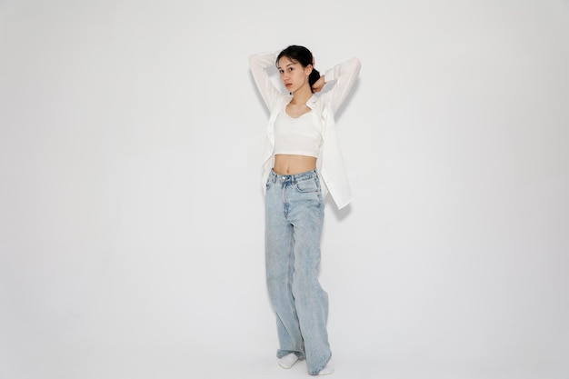 Young cute teen girl in jeans and shirt on a white background