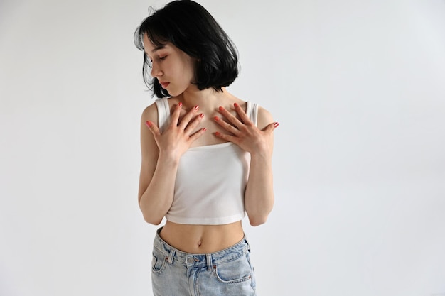 Young cute teen girl in jeans and shirt on a white background