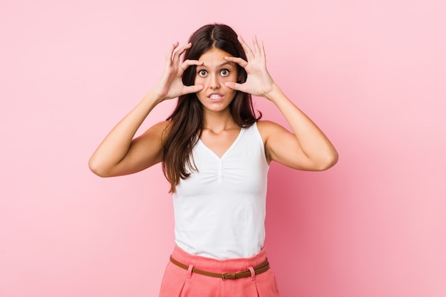 Young cute woman keeping eyes opened to find a success opportunity.