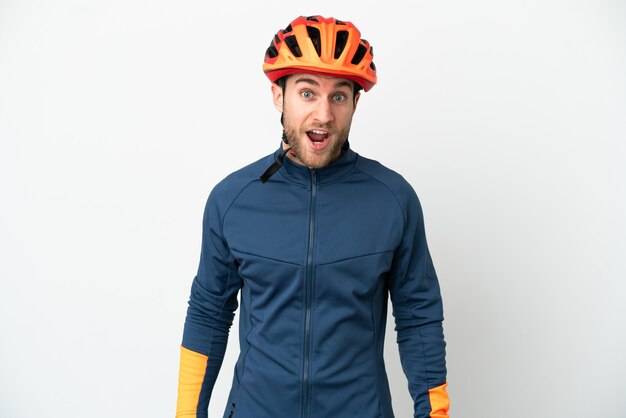 Young cyclist man isolated on white background with surprise facial expression