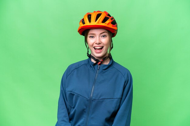 Young cyclist woman over isolated chroma key background with surprise facial expression