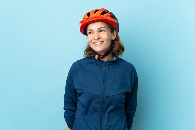 Young cyclist woman isolated thinking an idea while looking up