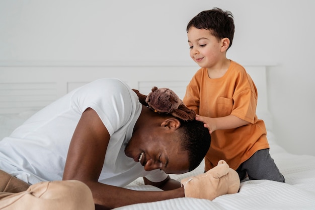 Young dad laughing and paying with his kid