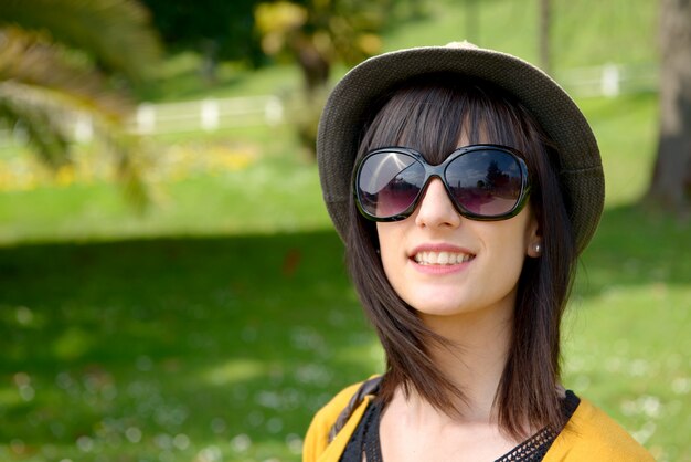 Young dark-haired woman with sunglasses in the park