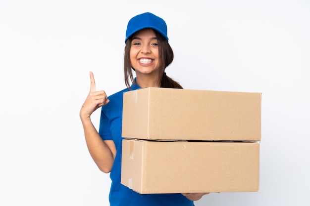 Young delivery brunette woman over isolated white wall pointing up a great idea