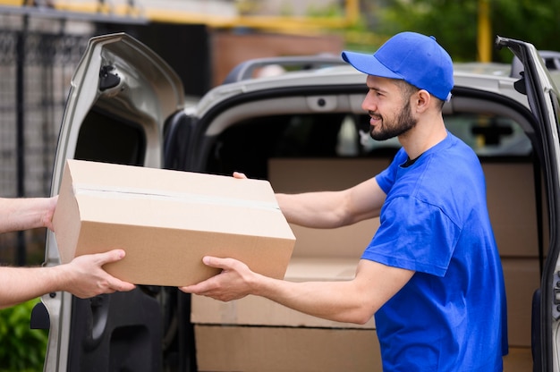 Young delivery man giving parcel to customer