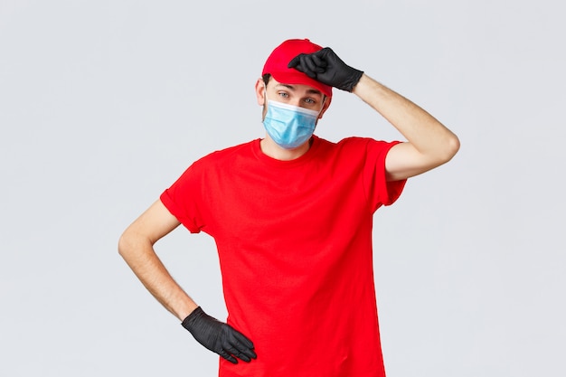 Young delivery man with a cap wearing protective mask