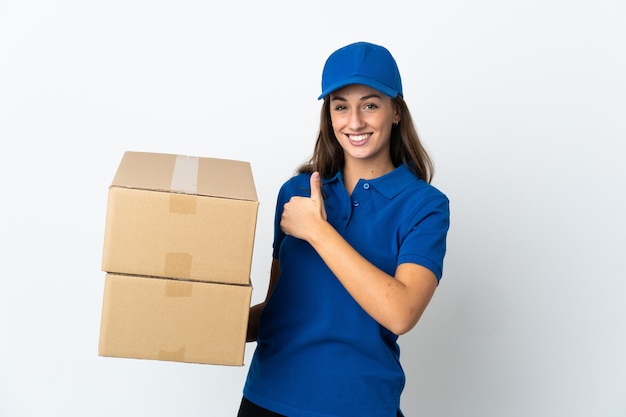 Young delivery woman over isolated white wall giving a thumbs up gesture