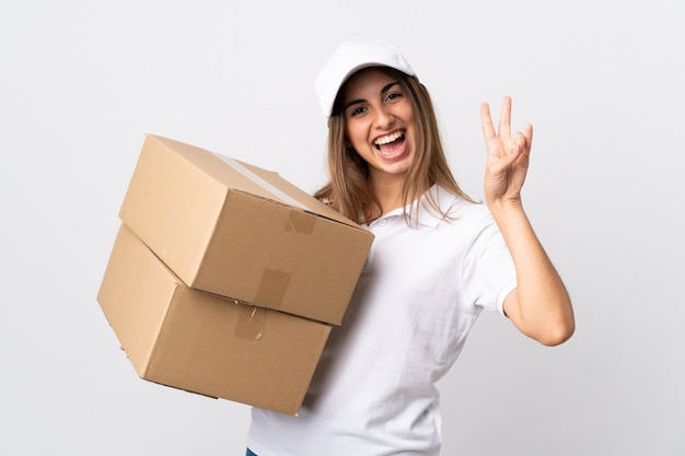 Young delivery woman over isolated white wall smiling and showing victory sign