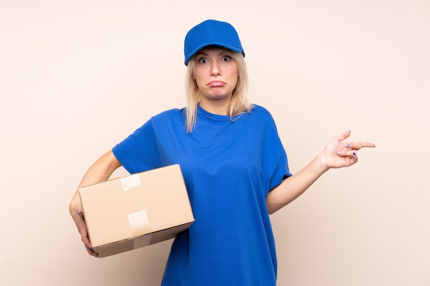 Young delivery woman pointing to the laterals having doubts