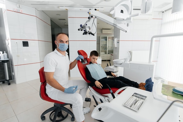 A young dentist examines and treats the teeth of an eightyearold boy in modern white dentistry closeup Dental prosthetics treatment and teeth whitening Modern dentistry Prevention