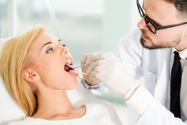 Young dentist examining patient in dental clinic.