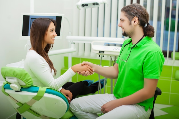 Young Dentist treating a female Patient in the dental studio