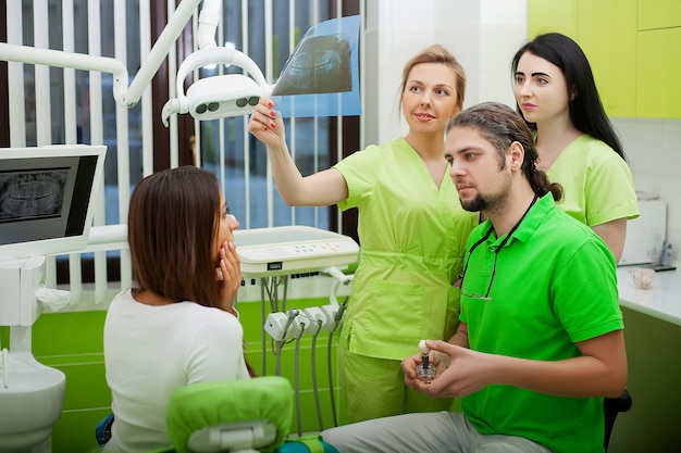 Young Dentist treating a female Patient in the dental studio