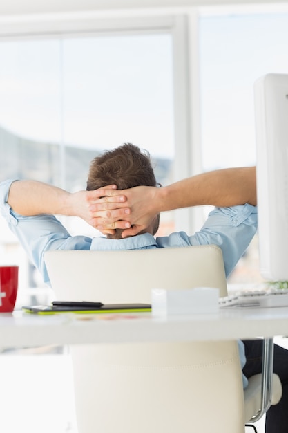 Young designer relaxing at his desk 