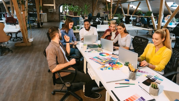 Young designers discussing new project in office