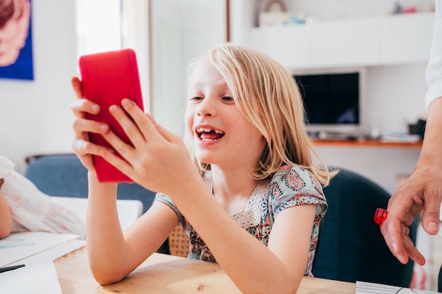 Young digital native female child indoor at home using phone