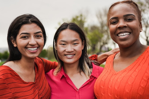 Young diverse women smiling on camera outdoor Multiethnic female friends having fun together at city park