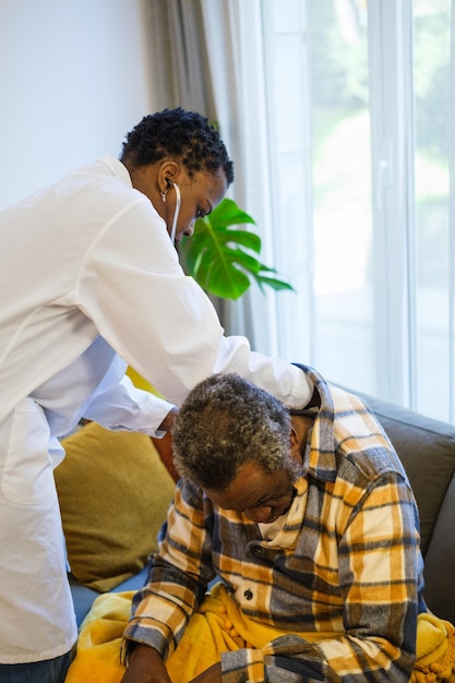 Young doctor doing a consultation at the home of the elderly patient to preserve his state of health and take care of himself Concept Health care doctor at home auscultation