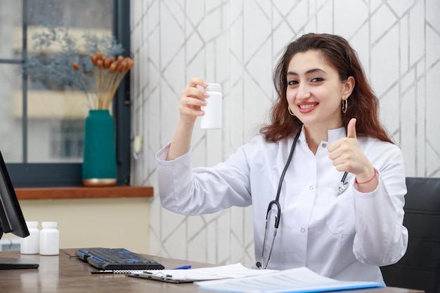 Young doctor holding drug capsule and gesture thumb up High quality photo