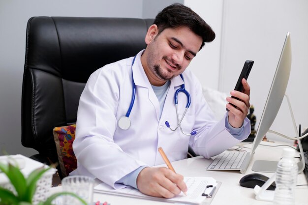 Photo a young doctor is sitting in the clinic talking to the patient on video call