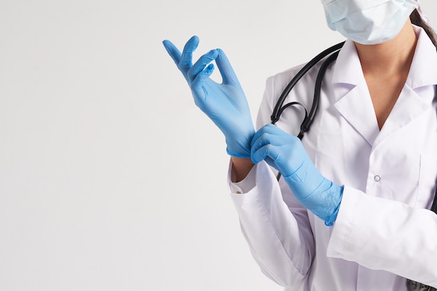 Young doctor putting on surgical gloves