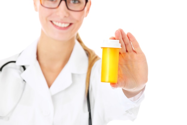 a young doctor showing a bottle of pills over white background