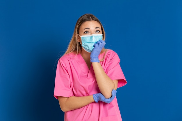 Young doctor wearing a mask face and a pink uniform